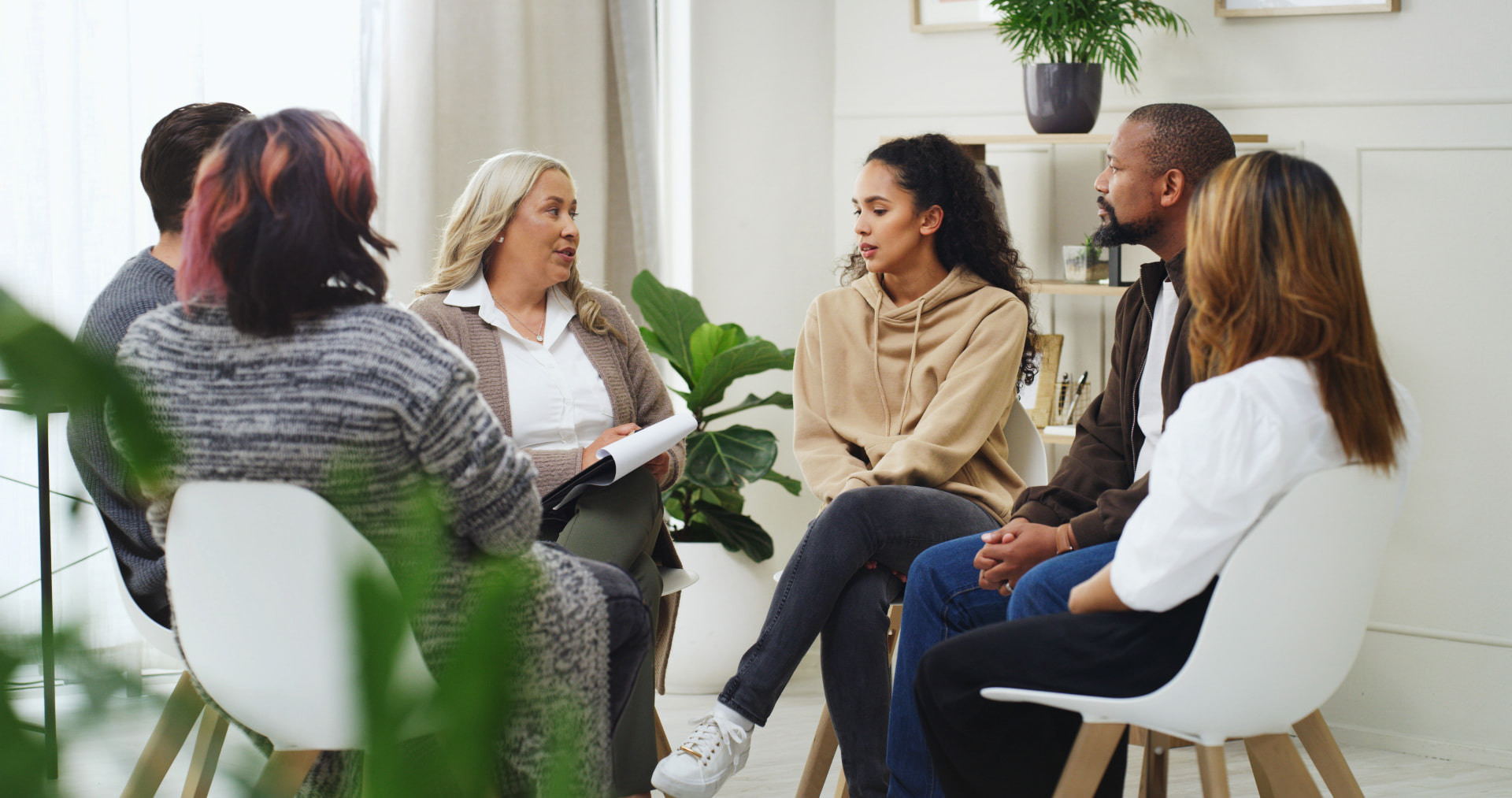 A therapist facilitating a supportive group therapy conversation